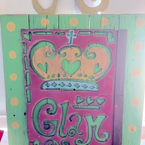 This is a wood decoration with metal. It says Glam in the metal.